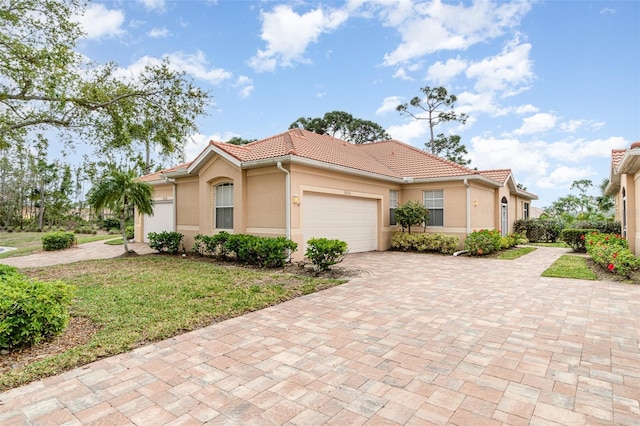3820 Cobia Villas Ct, Punta Gorda, FL 33955 - mediterranean / spanish-style home featuring an attached garage, a tiled roof, stucco siding, driveway, and a front yard