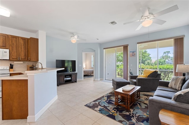 3820 Cobia Villas Ct, Punta Gorda, FL 33955 - living area with a ceiling fan, light tile patterned floors, and arched walkways