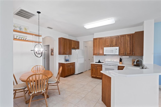 3820 Cobia Villas Ct, Punta Gorda, FL 33955 - kitchen featuring white appliances, a peninsula, brown cabinets, tasteful backsplash, and arched walkways