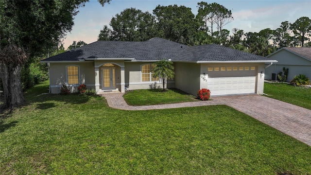 2697 Parrot St, North Port, FL 34286 - ranch-style home featuring stucco siding, an attached garage, driveway, a yard, and roof with shingles