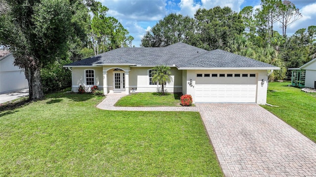 2697 Parrot St, North Port, FL 34286 - single story home with stucco siding, an attached garage, decorative driveway, a front lawn, and french doors