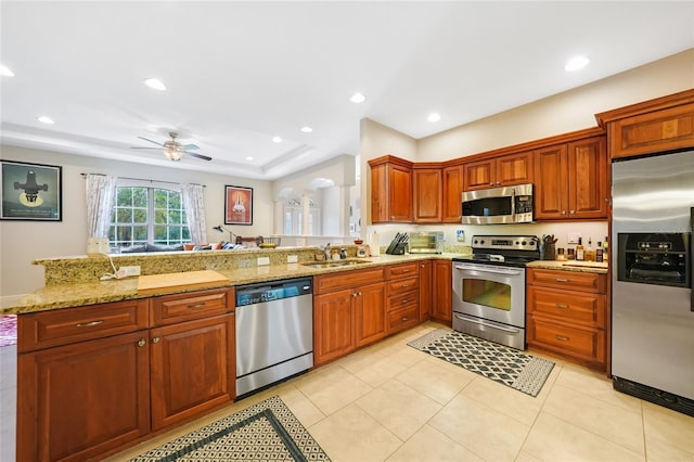 2697 Parrot St, North Port, FL 34286 - kitchen featuring stainless steel appliances, ceiling fan, a peninsula, light stone countertops, and recessed lighting