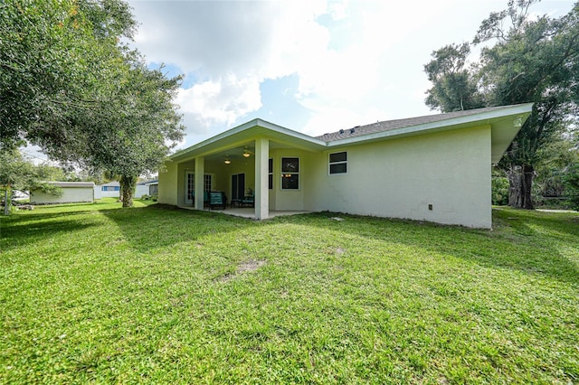 2697 Parrot St, North Port, FL 34286 - back of house with stucco siding, a patio area, and a yard