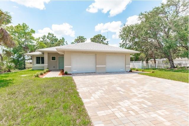9471-9473 Agate St, Port Charlotte, FL 33981 - view of front of house with stucco siding, a garage, and driveway