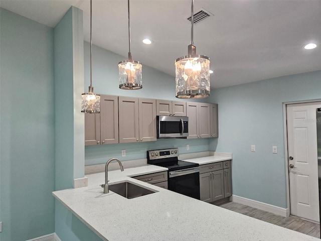 9471-9473 Agate St, Port Charlotte, FL 33981 - kitchen with appliances with stainless steel finishes, gray cabinetry, light wood-style flooring, decorative light fixtures, and vaulted ceiling