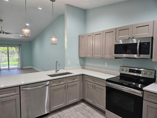 9471-9473 Agate St, Port Charlotte, FL 33981 - kitchen featuring stainless steel appliances, gray cabinets, light countertops, light wood-style flooring, and decorative light fixtures