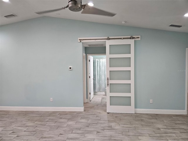9471-9473 Agate St, Port Charlotte, FL 33981 - unfurnished room with wood finished floors, lofted ceiling, ceiling fan, recessed lighting, and a barn door