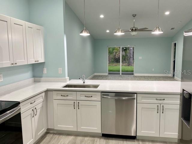 9471-9473 Agate St, Port Charlotte, FL 33981 - kitchen featuring stainless steel dishwasher, light countertops, white cabinetry, a ceiling fan, and decorative light fixtures