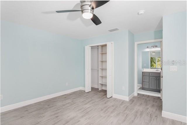 9471-9473 Agate St, Port Charlotte, FL 33981 - unfurnished bedroom featuring light wood finished floors, a closet, and a ceiling fan
