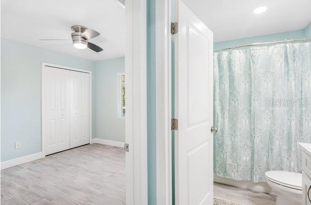 9471-9473 Agate St, Port Charlotte, FL 33981 - bathroom with wood finished floors, vanity, ceiling fan, and a shower with curtain