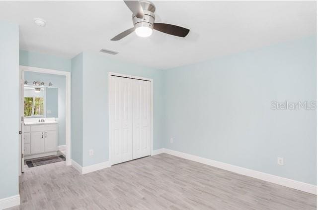 9471-9473 Agate St, Port Charlotte, FL 33981 - unfurnished bedroom with light wood finished floors, a closet, and a ceiling fan