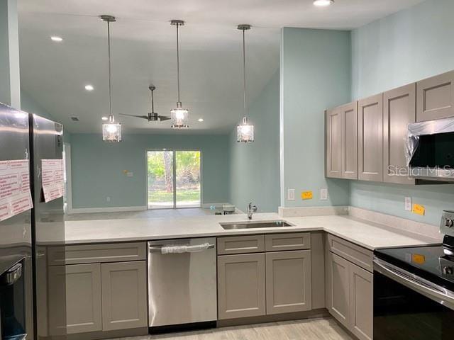 9471-9473 Agate St, Port Charlotte, FL 33981 - kitchen with appliances with stainless steel finishes, gray cabinets, a peninsula, light countertops, and light wood finished floors
