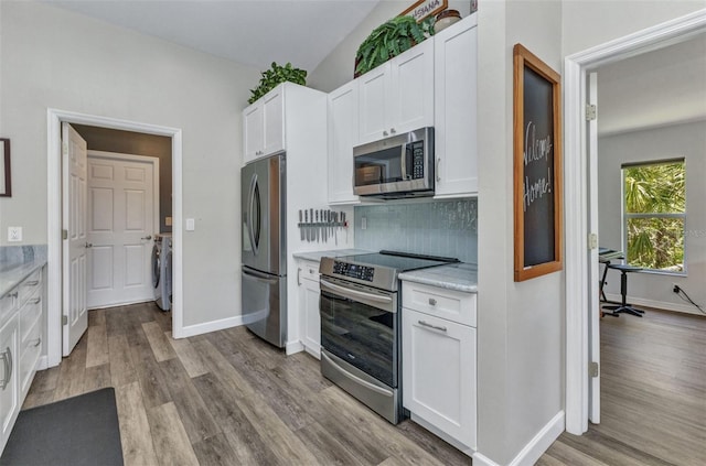 1445 Gauguin Rd, North Port, FL 34288 - kitchen with appliances with stainless steel finishes, light countertops, white cabinetry, backsplash, and light wood-style floors