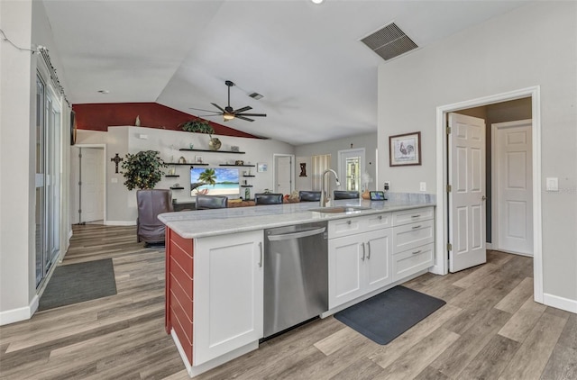 1445 Gauguin Rd, North Port, FL 34288 - kitchen with stainless steel dishwasher, a ceiling fan, vaulted ceiling, light wood-type flooring, and a peninsula