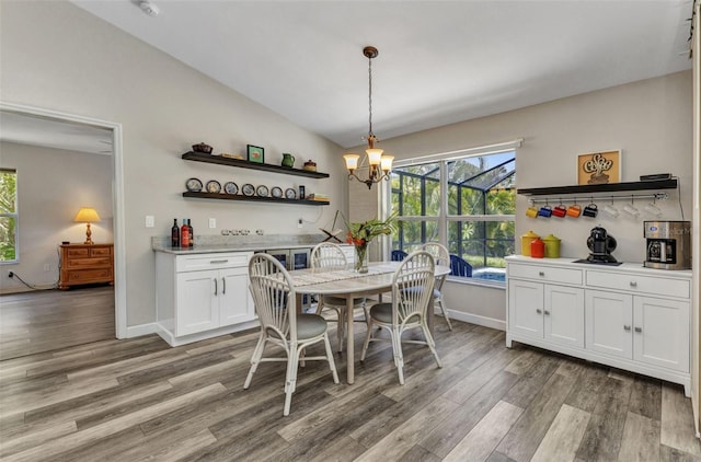 1445 Gauguin Rd, North Port, FL 34288 - dining room featuring light wood-style floors, a chandelier, and lofted ceiling