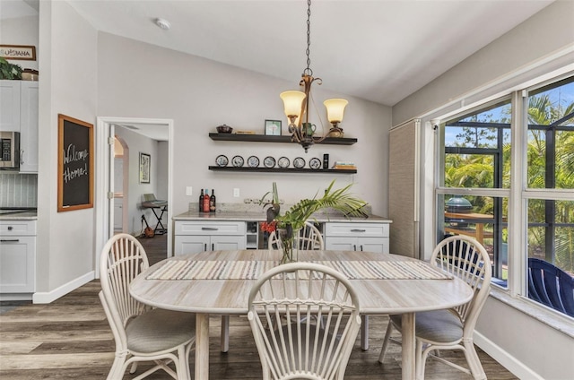 1445 Gauguin Rd, North Port, FL 34288 - dining room with lofted ceiling, dark wood-style floors, and a chandelier