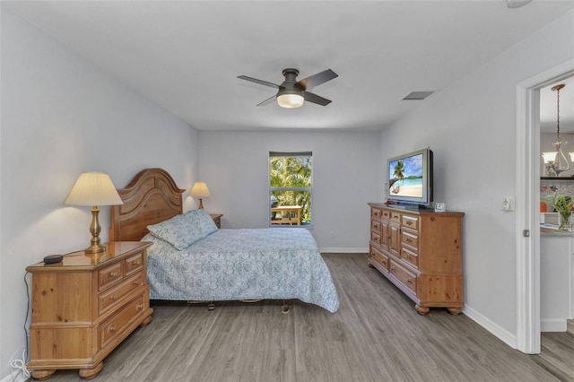 1445 Gauguin Rd, North Port, FL 34288 - bedroom featuring wood finished floors, a ceiling fan, and a chandelier