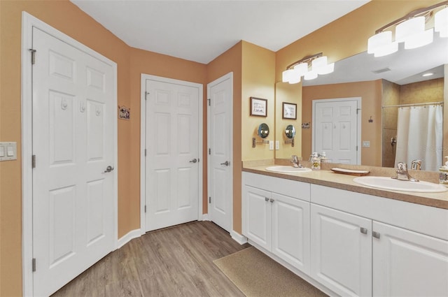 1445 Gauguin Rd, North Port, FL 34288 - full bathroom with wood finished floors, double vanity, and a shower with shower curtain