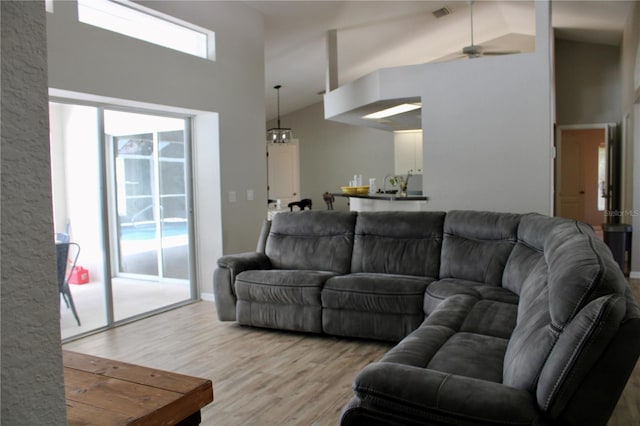 8039 Agate St, Port Charlotte, FL 33981 - living area with high vaulted ceiling, wood finished floors, a ceiling fan, and a chandelier