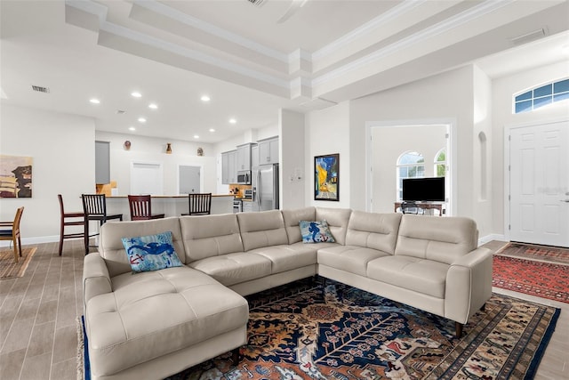 2453 Harbour Dr, Punta Gorda, FL 33983 - living room featuring ornamental molding, recessed lighting, light wood-style floors, and a tray ceiling