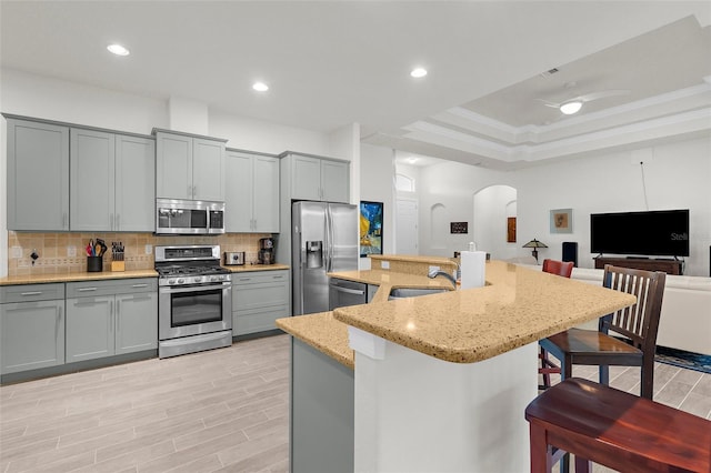 2453 Harbour Dr, Punta Gorda, FL 33983 - kitchen featuring stainless steel appliances, gray cabinets, a breakfast bar, arched walkways, and recessed lighting