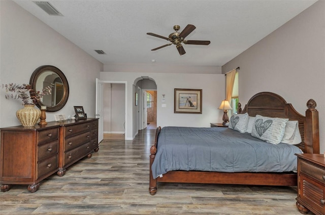 771 Rotonda Cir, Rotonda West, FL 33947 - bedroom with arched walkways, wood finished floors, and ceiling fan