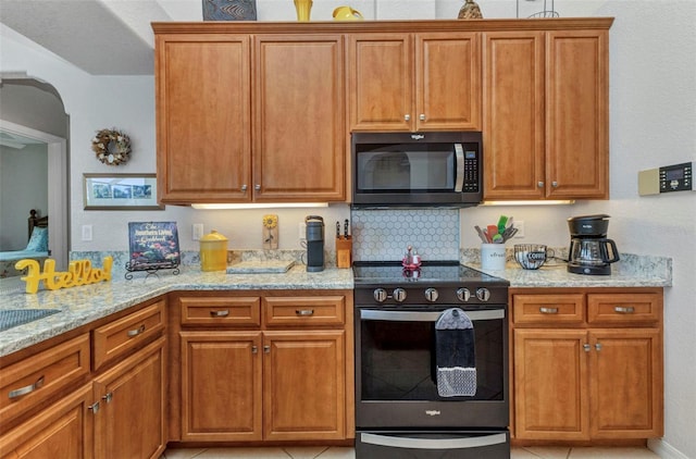 771 Rotonda Cir, Rotonda West, FL 33947 - kitchen featuring stainless steel electric stove, light stone countertops, brown cabinetry, and arched walkways