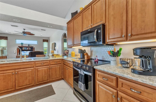 771 Rotonda Cir, Rotonda West, FL 33947 - kitchen featuring stainless steel range with electric cooktop, light stone countertops, brown cabinetry, light tile patterned flooring, and tasteful backsplash