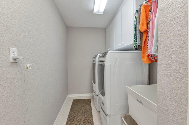 771 Rotonda Cir, Rotonda West, FL 33947 - laundry area with washer and clothes dryer, cabinet space, light tile patterned floors, and a textured wall