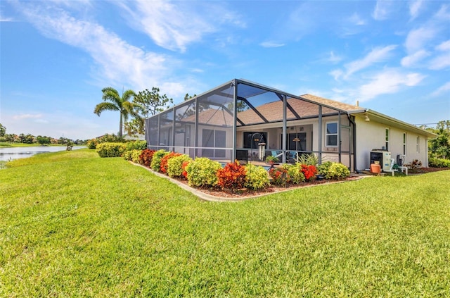 771 Rotonda Cir, Rotonda West, FL 33947 - rear view of property with a lawn, a water view, a lanai, and stucco siding