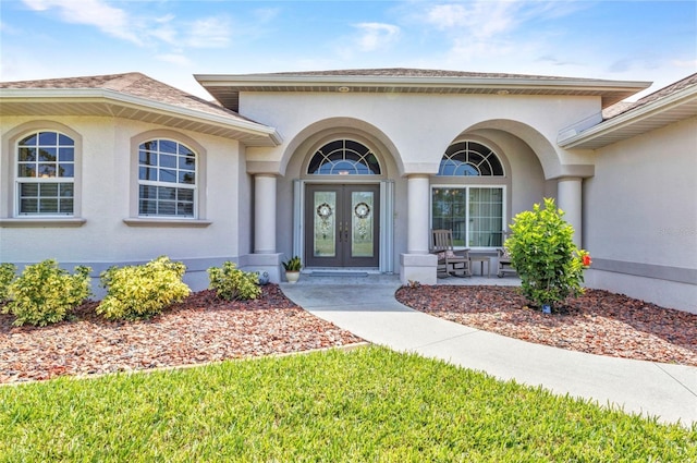 771 Rotonda Cir, Rotonda West, FL 33947 - property entrance featuring french doors, stucco siding, and covered porch