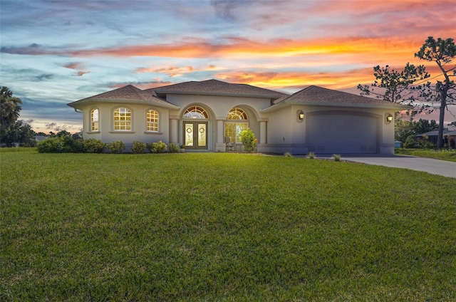 771 Rotonda Cir, Rotonda West, FL 33947 - mediterranean / spanish-style house with french doors, a yard, a garage, concrete driveway, and stucco siding