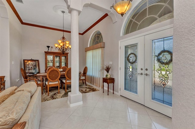 771 Rotonda Cir, Rotonda West, FL 33947 - foyer entrance with french doors, a chandelier, light tile patterned floors, decorative columns, and ornamental molding