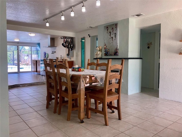 232 Darst Ave, Punta Gorda, FL 33950 - dining area with light tile patterned floors, a textured ceiling, a textured wall, french doors, and track lighting