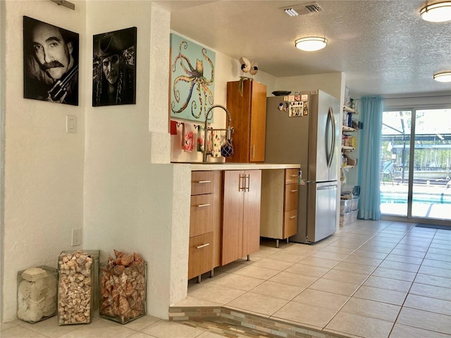232 Darst Ave, Punta Gorda, FL 33950 - kitchen with freestanding refrigerator, light tile patterned flooring, a textured ceiling, and light countertops