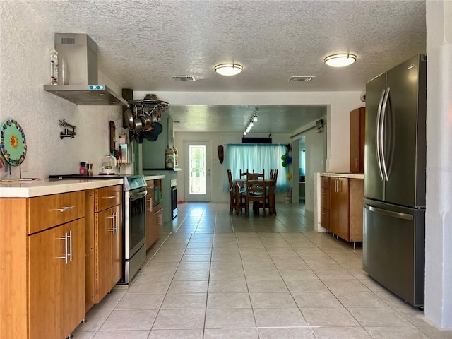 232 Darst Ave, Punta Gorda, FL 33950 - kitchen featuring stainless steel appliances, exhaust hood, light tile patterned floors, light countertops, and a textured ceiling