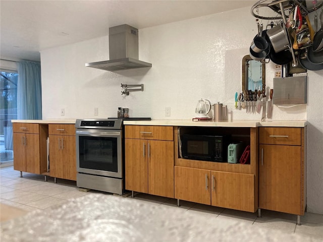 232 Darst Ave, Punta Gorda, FL 33950 - kitchen with electric stove, wall chimney exhaust hood, black microwave, light countertops, and brown cabinets