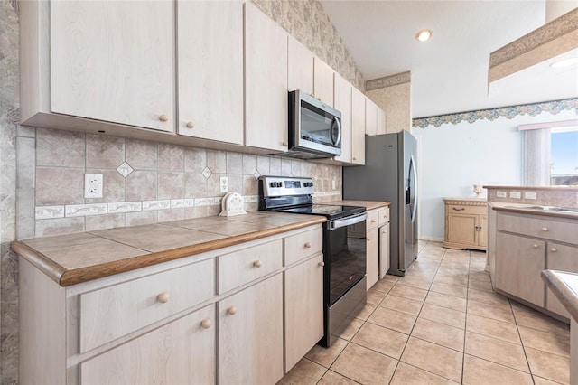 574 Macedonia Dr, Punta Gorda, FL 33950 - kitchen with stainless steel appliances, light tile patterned floors, tasteful backsplash, and tile counters