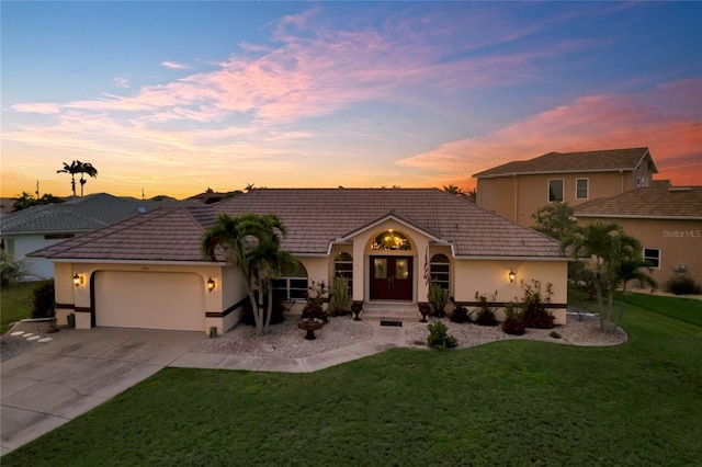 574 Macedonia Dr, Punta Gorda, FL 33950 - view of front of property featuring an attached garage, a front yard, driveway, stucco siding, and a tile roof
