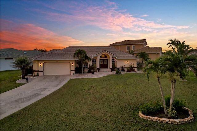 574 Macedonia Dr, Punta Gorda, FL 33950 - mediterranean / spanish-style home with a garage, stucco siding, and a lawn