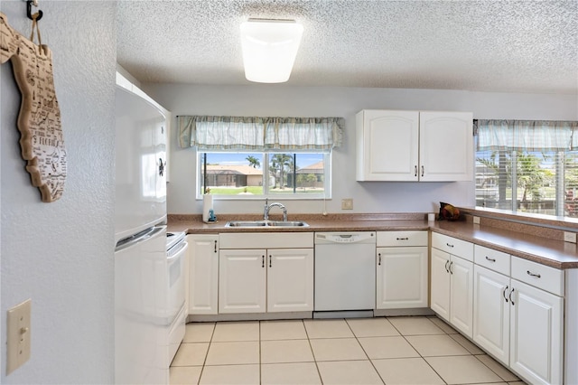 17103 Horizon Ln, Port Charlotte, FL 33948 - kitchen featuring white appliances, a textured ceiling, healthy amount of natural light, and white cabinetry