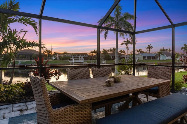 17103 Horizon Ln, Port Charlotte, FL 33948 - patio terrace at dusk featuring a water view, glass enclosure, and outdoor dining space