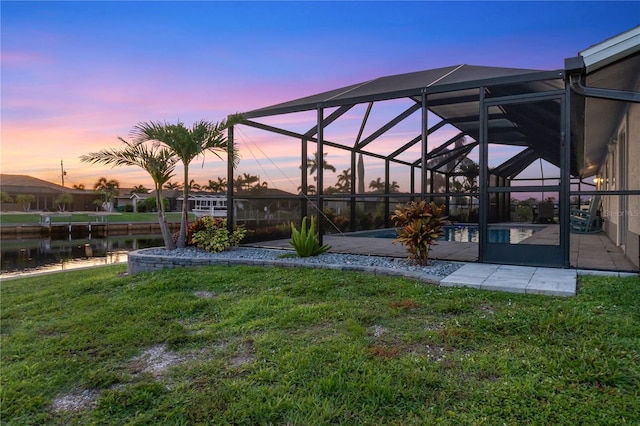 17103 Horizon Ln, Port Charlotte, FL 33948 - yard at dusk featuring an outdoor pool, a yard, a patio, and a water view