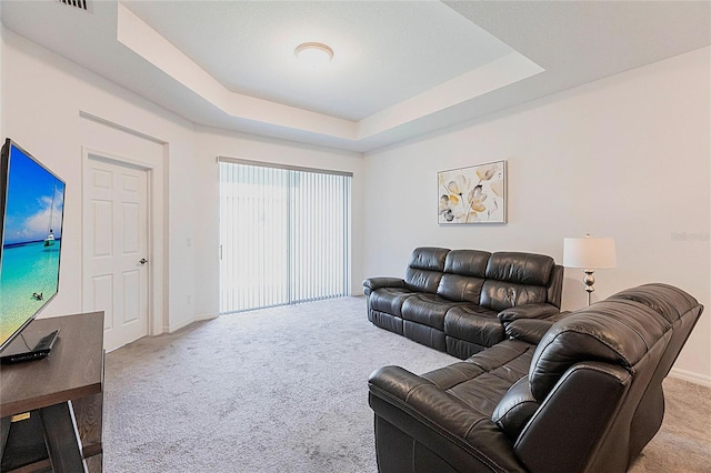 8516 Cache Dr, Sarasota, FL 34240 - carpeted living room with a tray ceiling and baseboards