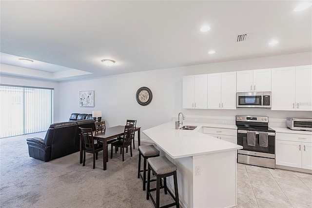 8516 Cache Dr, Sarasota, FL 34240 - kitchen with appliances with stainless steel finishes, a breakfast bar, a peninsula, open floor plan, and light countertops
