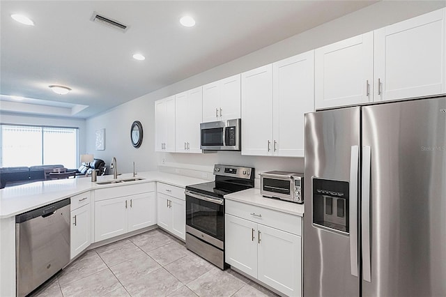 8516 Cache Dr, Sarasota, FL 34240 - kitchen with stainless steel appliances, light tile patterned flooring, open floor plan, recessed lighting, and white cabinets