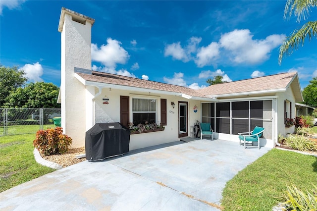 22559 Adorn Ave, Port Charlotte, FL 33952 - back of property featuring stucco siding, a patio, a chimney, and a sunroom