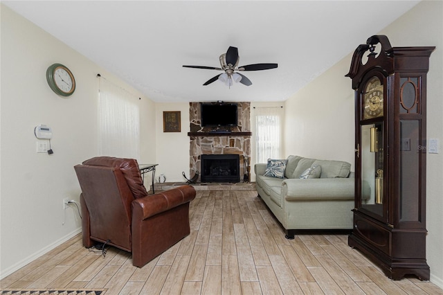 22559 Adorn Ave, Port Charlotte, FL 33952 - living room featuring a ceiling fan, light wood finished floors, and a stone fireplace