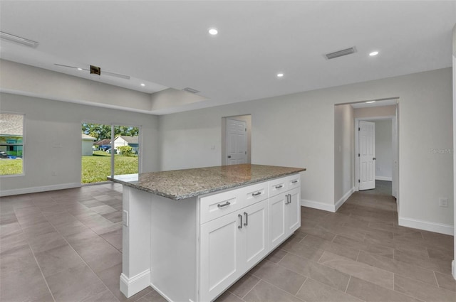 3435 W Price Blvd, North Port, FL 34286 - kitchen with light stone counters, recessed lighting, open floor plan, white cabinetry, and a center island