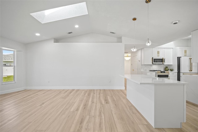 25451 Kowloon Ln, Punta Gorda, FL 33983 - kitchen with stainless steel microwave, range, lofted ceiling, a skylight, and light wood-style flooring